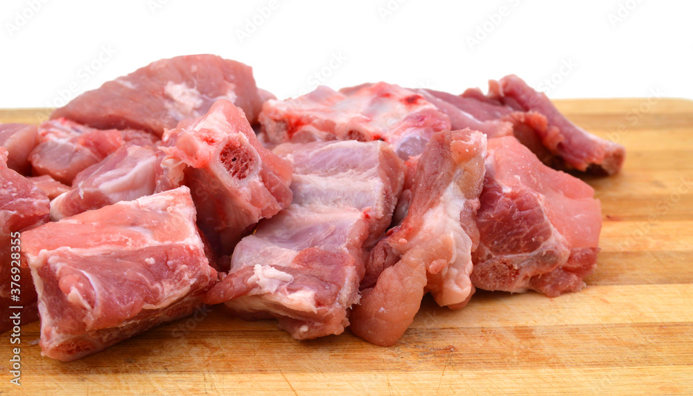 Slices of fresh raw pork meat isolated in wooden board on white background