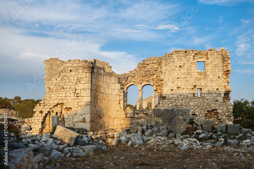 Ruins of building (probably church) lighted by sunlight in ancient city Kanli Divane or Canytelis, Ayaş, Turkey. City was part of Roman Empire & then abandoned. Now it's sight for tourists photo