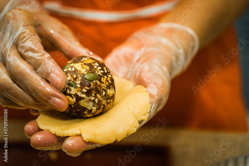 Female hands making dough for mooncake, homemade cantonese moon cake pastry on baking tray before baking for traditional festival. photo