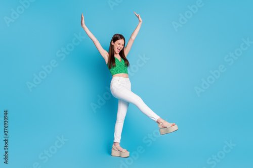 full length photo of crazy candid girl scream raise hands enjoy free time holiday wear good look clothes isolated over blue color background © deagreez