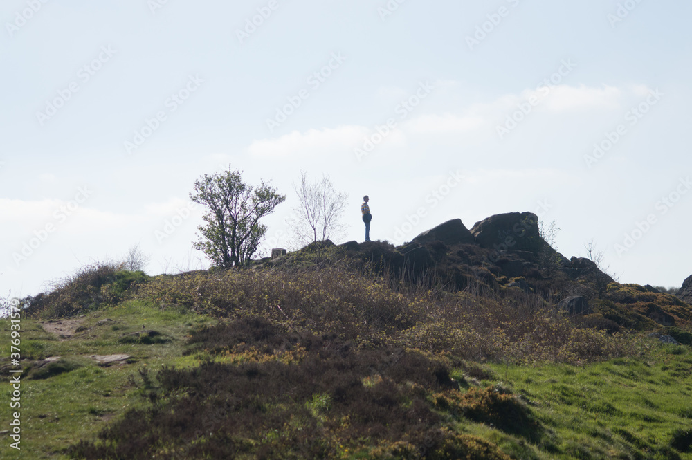 A man peering over the top of the Otley Chevin.