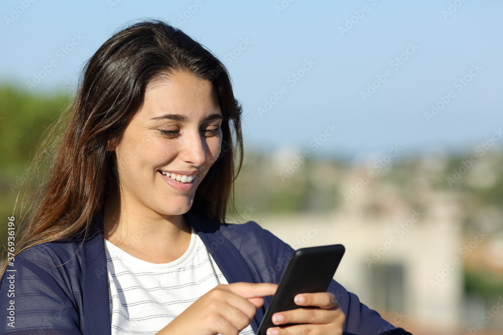 Woman checking smart phone outdoors