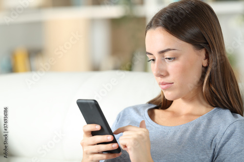 Teen using smart phone sitting at home
