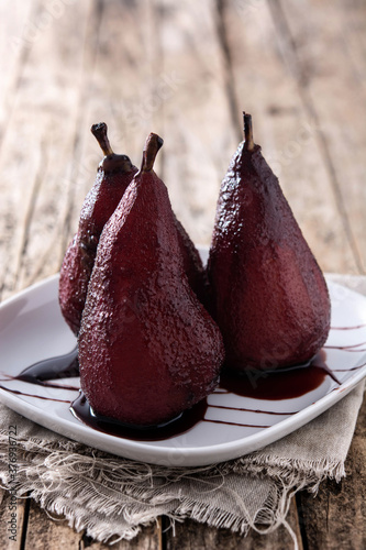 Poached pears in red wine on wooden table