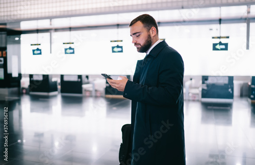 Serious man surfing cellphone in airport