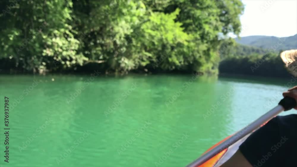 Back view of a Girl rowing in the Soca river, Slovenia Back view of a Girl rowing in the Soca river, Slovenia