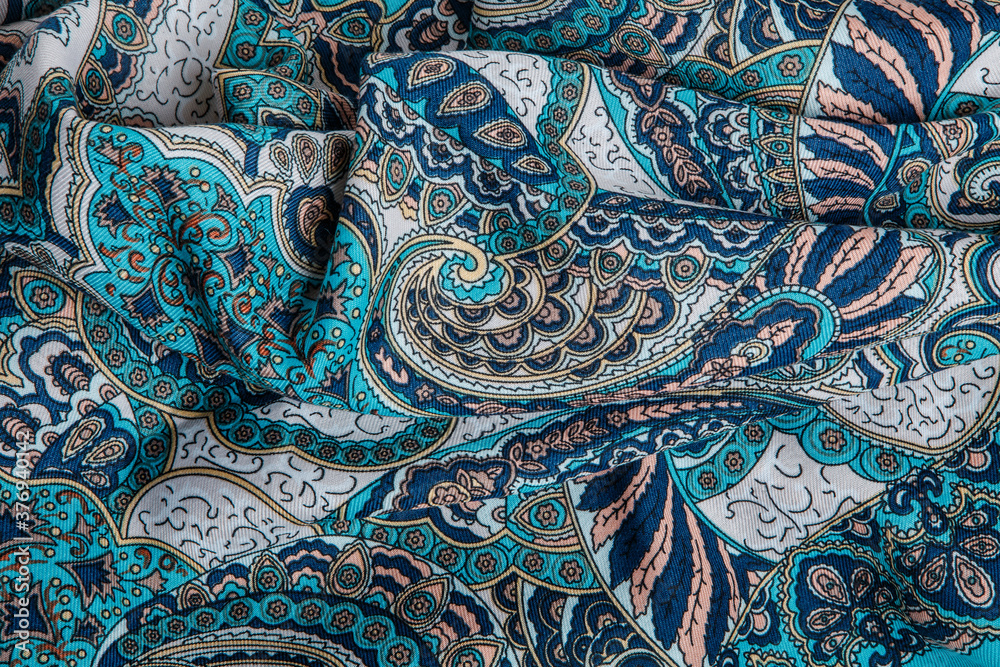 top view closeup on crumpled blue soft cotton scarf with bright oriental ornament