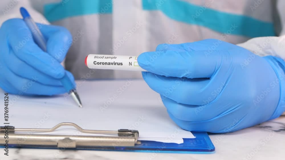 laboratory technician hand holding blood test tube and writing on paper laboratory technician hand holding blood test tube and writing on paper
