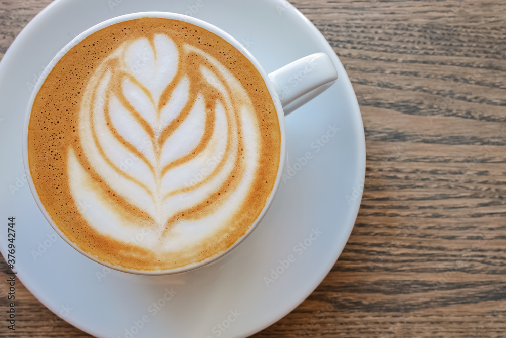 Cappuccino coffee dressing with leave shape of latte art on wood table, Cappuccino coffee dressing with leave shape of latte art on wood table,