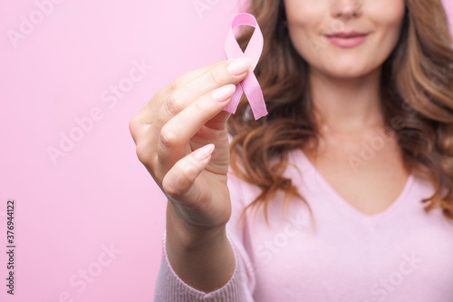 Murais de parede Woman in pink sweater with pink ribbon supporting breast cancer awareness campai