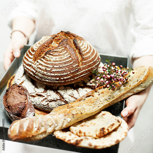 Midsection of man holding tray of breads