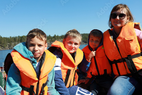 Mother with sons in life jacket on boat