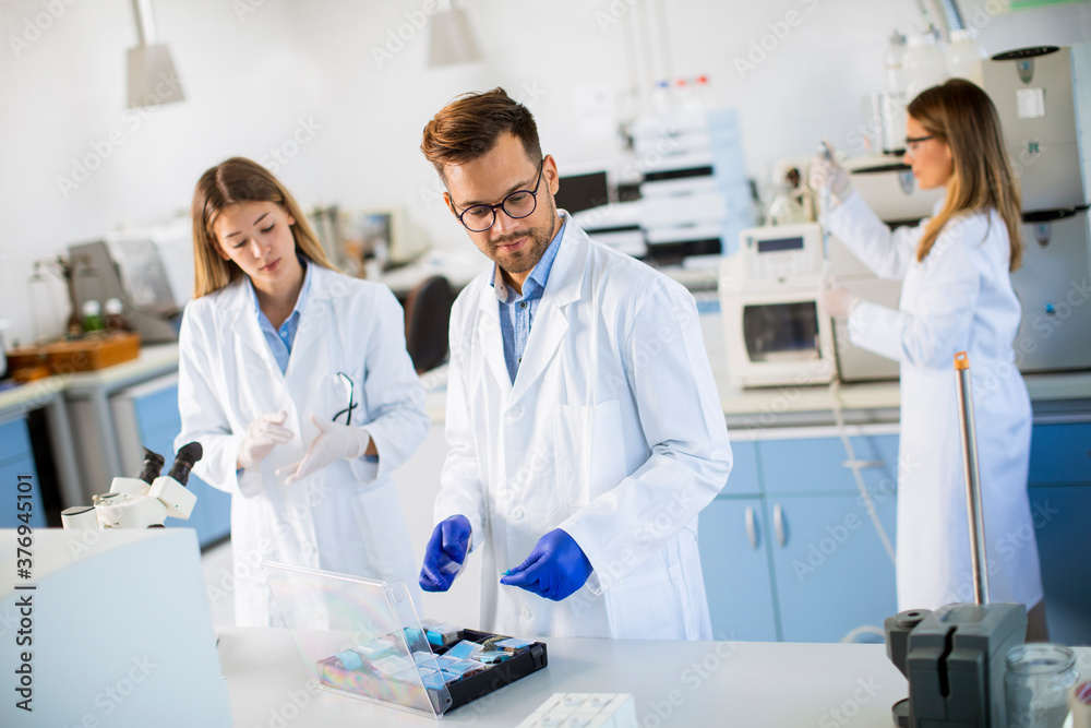 Group of young researchers analyzing chemical data in the laboratory Group of young researchers analyzing chemical data in the laboratory
