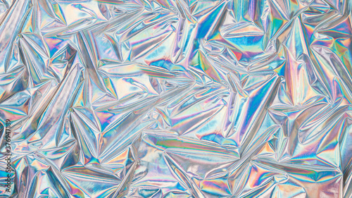 Holographic iridescent surface wrinkled vaporwave background. Trendy design texture with multiple colors of webpunk in 80's style.