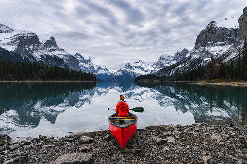 Cuadro en lienzo Traveler sitting with paddle on canoe in Maligne lake at Spirit Island