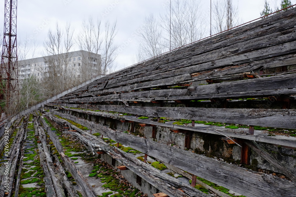 The stands of an abandoned stadium in Pripyat. Old wooden benches in the stadium. The stands of an abandoned stadium in Pripyat. Old wooden benches in the stadium.