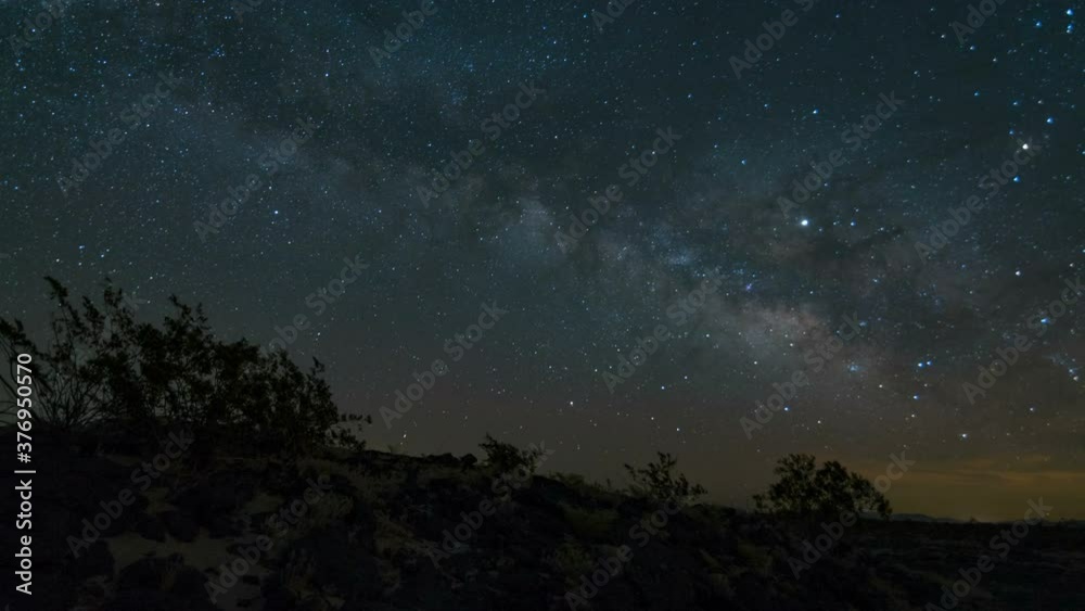 Astro timelapse of Milky Way galaxy tracking over volcanic rocks in Mojave Desert in California Astro timelapse of Milky Way galaxy tracking over volcanic rocks in Mojave Desert in California