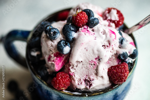 Summer dessert with ice cream, blueberries, raspberries and bilberries photo