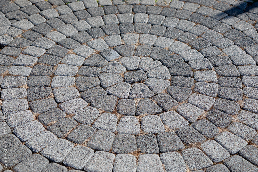 Round stone pavement pattern. Sidewalk tiles laid out from the center. Round stone pavement pattern. Sidewalk tiles laid out from the center.