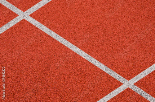 Top view of the running track rubber lanes cover texture with white line marking for background. © tkroot