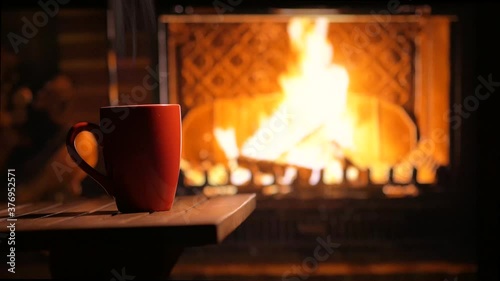 A cup of hot tea in front of the fireplace on a cozy evening. Festive mood