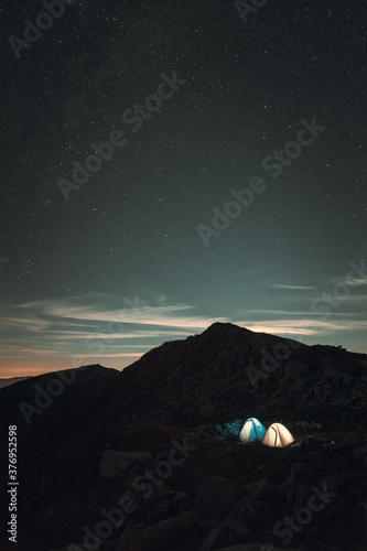 Two tents on the mountain in the night with stars