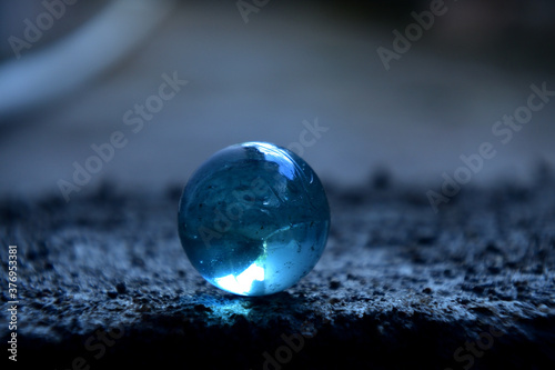 Transparent blue marbles with blur background © adityajati