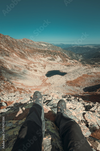 Amazing wide angle shot with mountain landscape in background and men feet 
