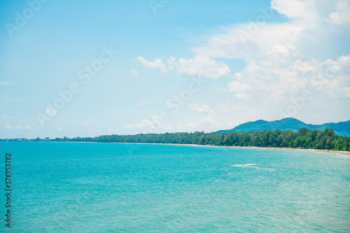 Landscape with white beach, the sea and the beautiful clouds in the blue sky