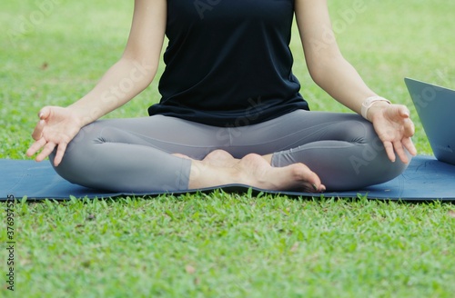 In the lotus posture close up , Yoga in the park, outdoor with effect light, healthy woman. Concept of healthy lifestyle and relaxation.