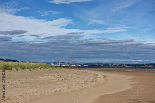 Oil Rigs in for a Refit at the port of Dundee seen from Tentsmuir Point and its gently shelving Beach at Low tide on a sunny day in August.