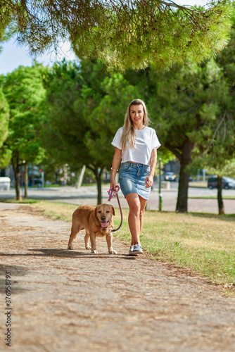 woman walking the dog in the park © JENOCHE