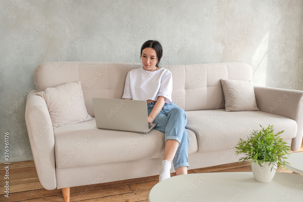 Freelance concept. The concentrated girl looks attentively into the laptop monitor. 