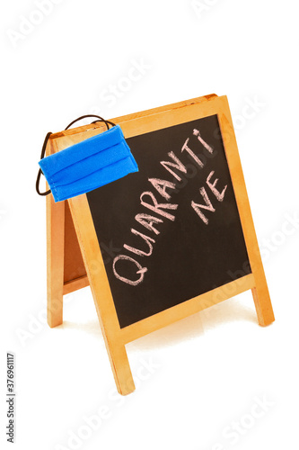 Coronavirus concept with text quarantine, announcement on board, blackboard, chalkboard, frame and blue protective medicine hygienic equipment mask. Isolated on white background.