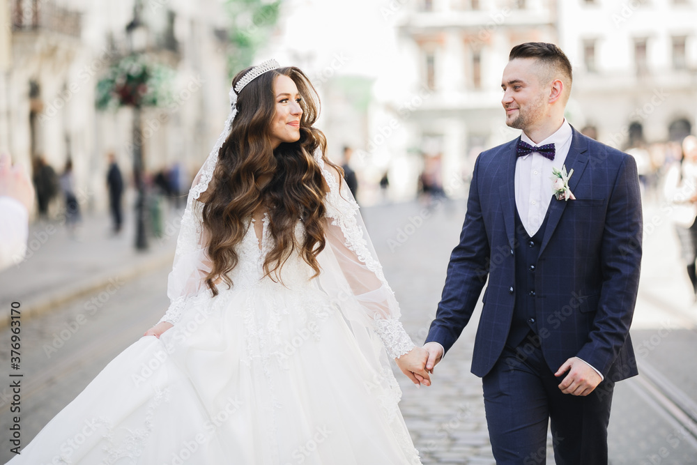 A loving wedding couple are walking back along the streets of the city of Lviv