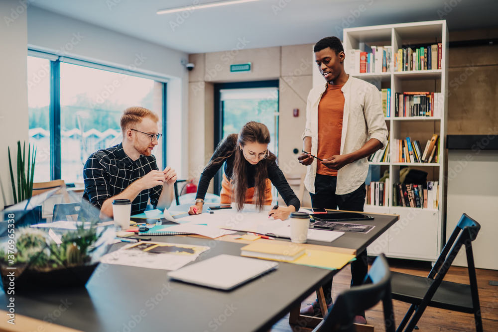 Diverse active colleagues developing project together Diverse active colleagues developing project together