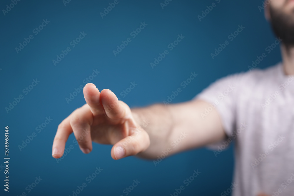 young man finger pointing touch blue background