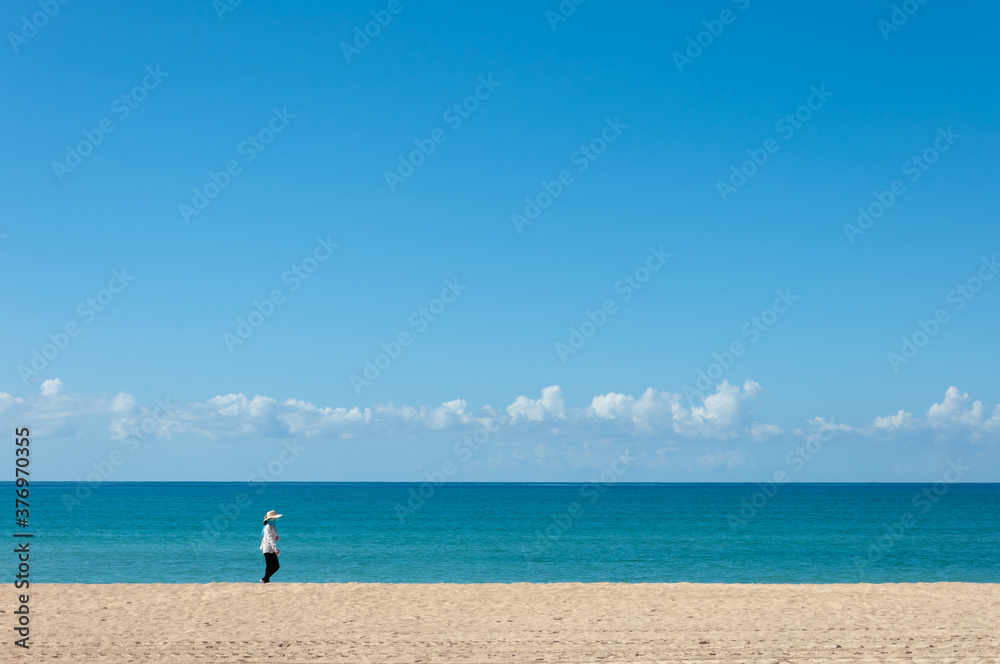 Unrecognizable person walking on a totally empty beach