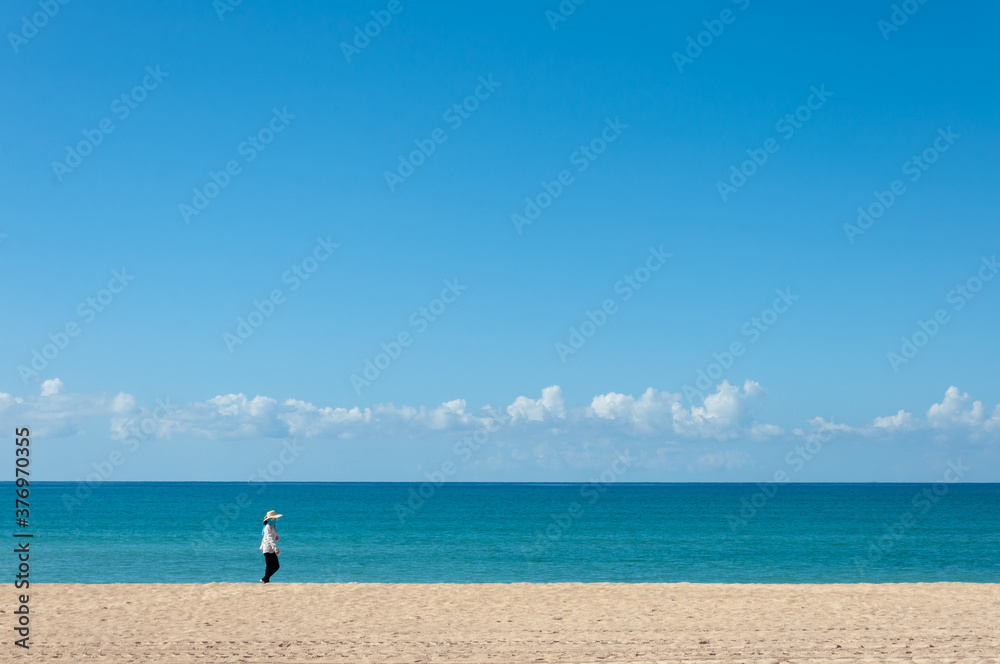Unrecognizable person walking on a totally empty beach Unrecognizable person walking on a totally empty beach