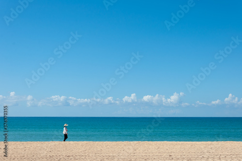 Unrecognizable person walking on a totally empty beach