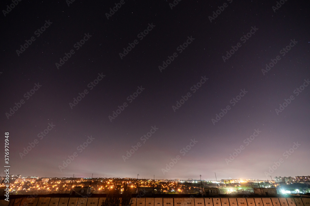 Fototapeta premium Night starry sky with a lot of stars and constellations in the city.