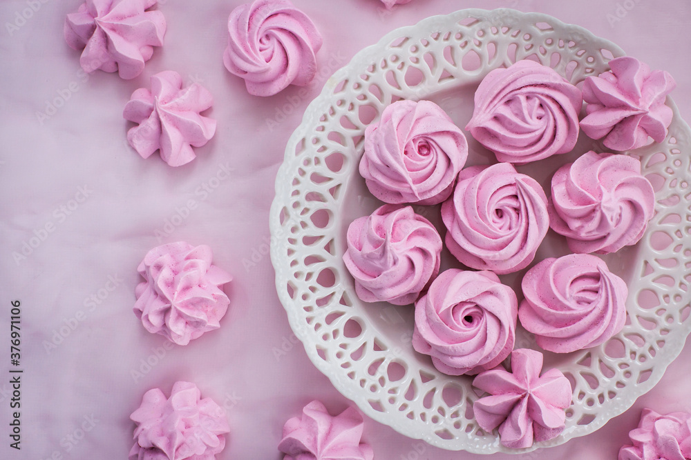 Pink meringues on plate, colorful background, top view Pink meringues on plate, colorful background, top view