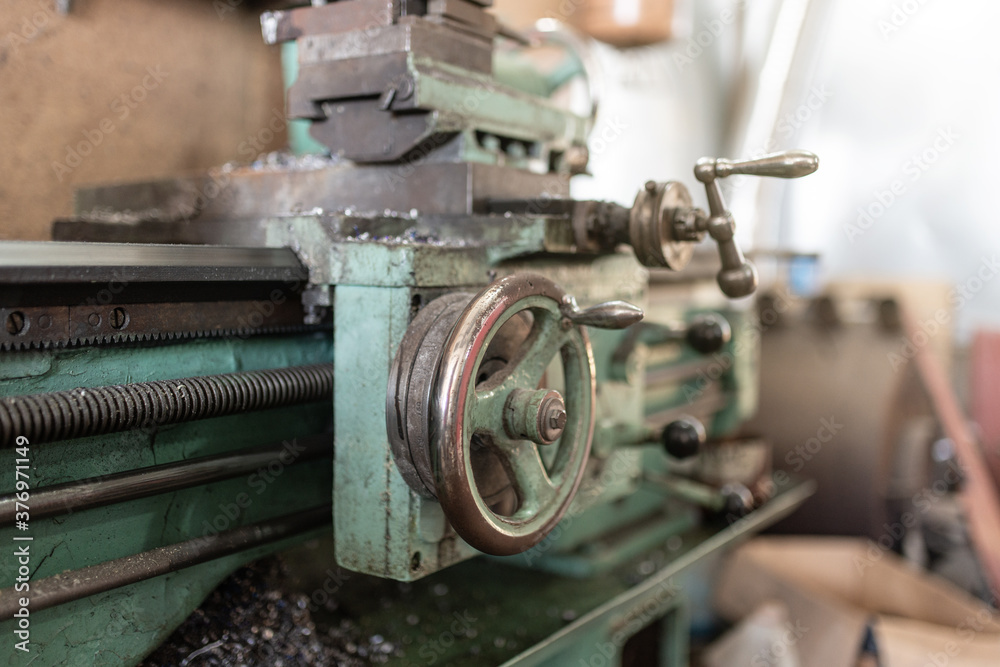 The old lathe machine is painted green. The old lathe machine is painted green.