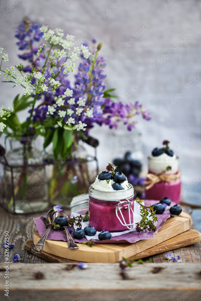 Blueberry Panna Cotta decorated with cream and fresh berries