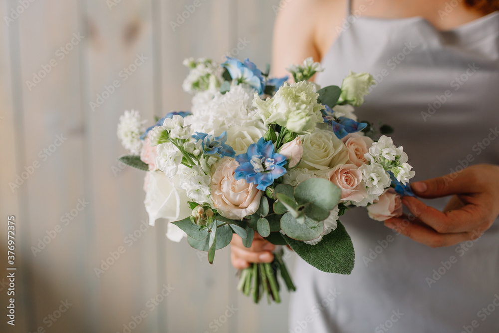 Young florist woman holding freshly made blossoming flower bouquet