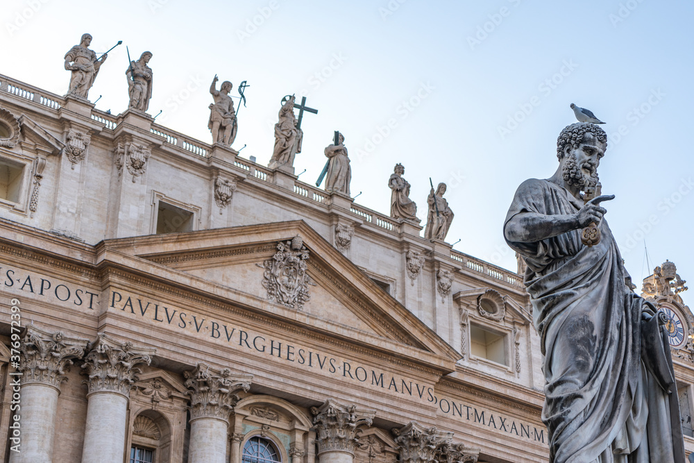 Statue of Saint Peter and Saint Peter's Basilica at background in St. Peter's Square, Vatican City, Rome