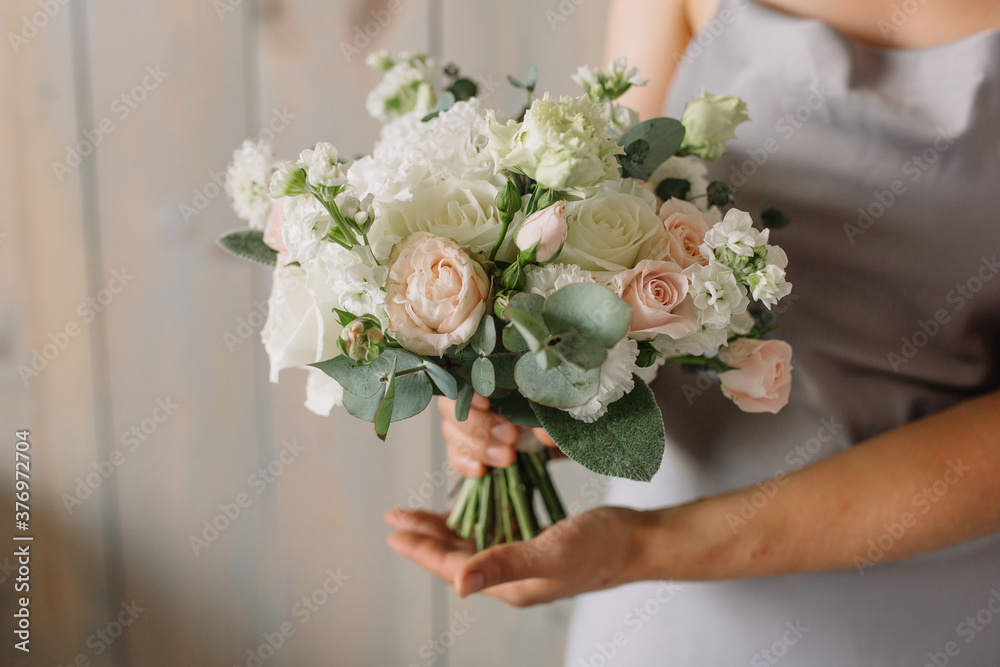 Cheerful young lady with long wavy hair being excited to get bouquet