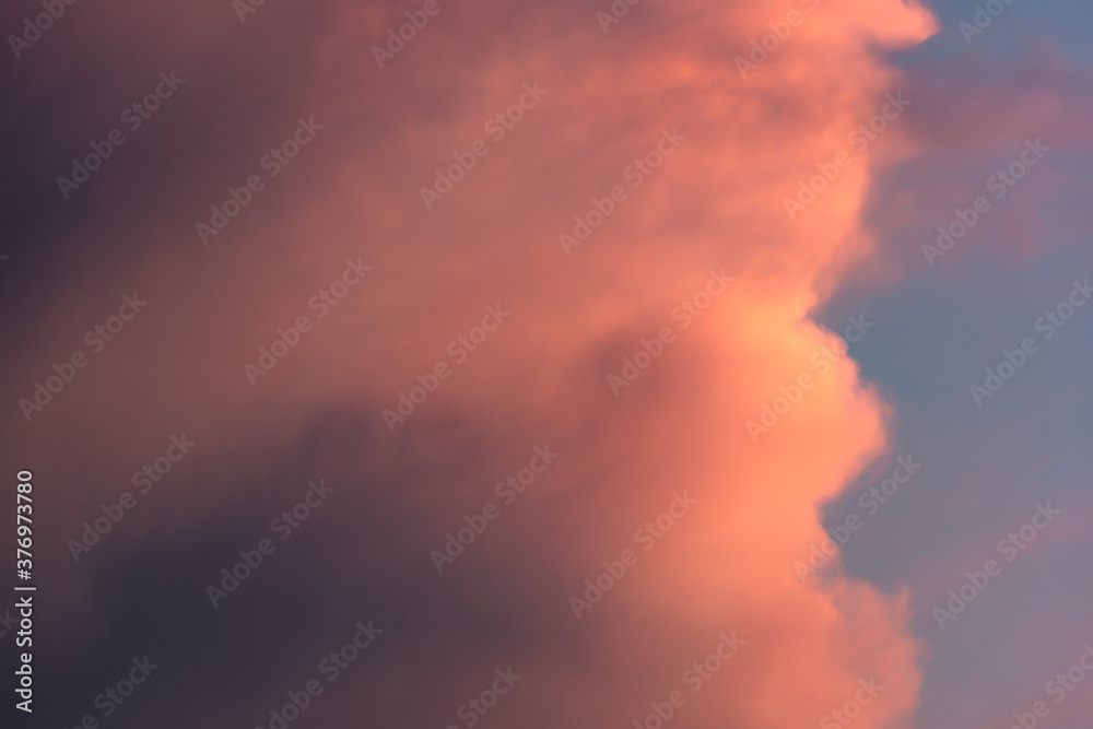 Dramatic sky background with pink and violet fluffy cloud looks like cotton candy or candy right before a thunderstorm in summer