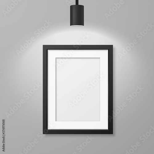 Vector 3d Realistic A4 Black Wooden Simple Modern Frame for Presentstion on a White Wall Background with a Luminous Spot Lamp on Top, Above Frame. Design Template for Mockup, Front View photo