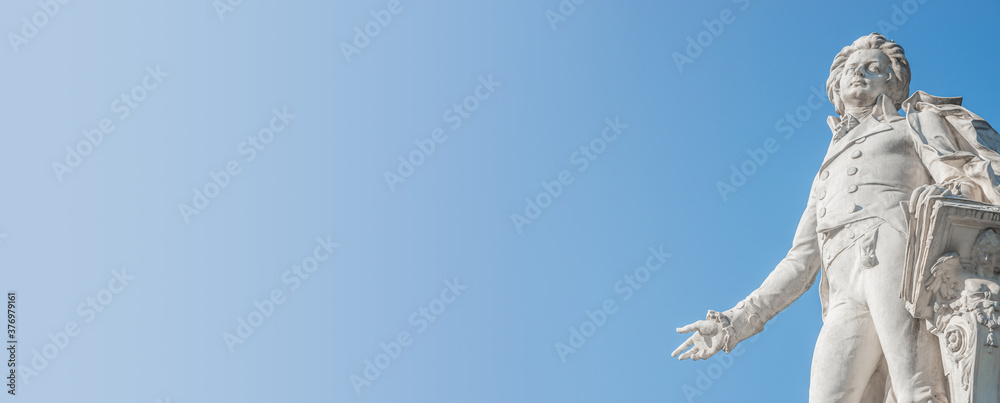 Banner with Mozart monument in historical downtown of Vienna, Austria at sunny day, blue sky with copy space for text, details - obrazy, fototapety, plakaty 